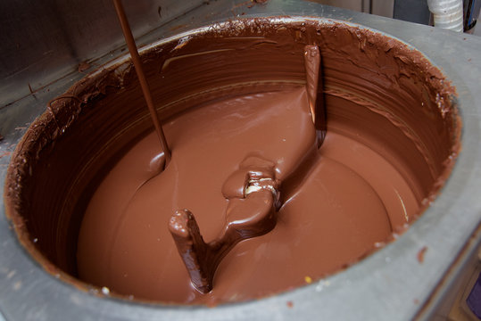 Preparation of milk chocolate at the candy factory. Sweet dessert. Machine for mixing chocolate mass.