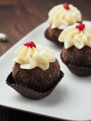 Cupcakes with whipped cream on brown wooden table