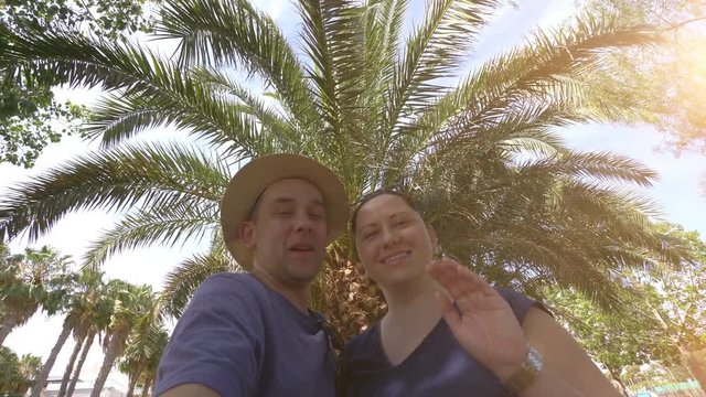 Happy couple taking a selfie and sending greetings in tropical resort in 4k slow motion  60fps