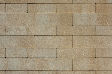 The surface is paved with road tiles of different sizes (multiformat). The uneven (melange) color of the tile makes it look like a natural stone. View from above.