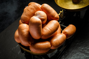 closeup heap of short thick wieners rolled in spiral on scales