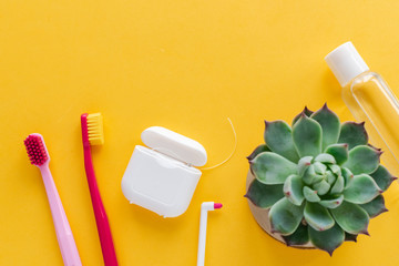 Dental hygiene - tooth brushes, dental floss, mouthwash flat lay, top view, copy space, yellow...