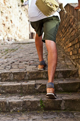 Walking upstairs: closeup view of man's legs brown leather shoes going upstairs.