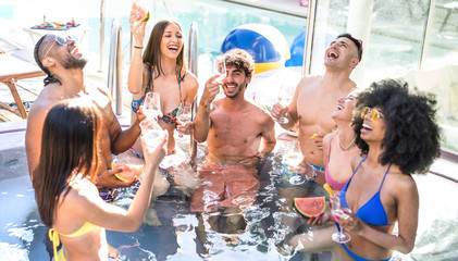 Side view of happy friends group drinking white wine champagne at swimming pool party - Luxury...