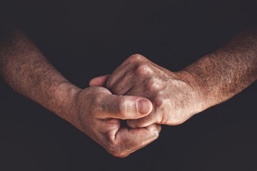 Fototapeta premium Hands of an elderly man worker closeup on a black background