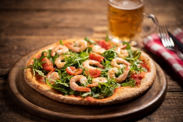 Pizza covered with roquette and shrimps