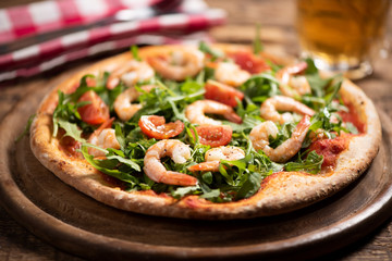 Pizza covered with roquette and shrimps