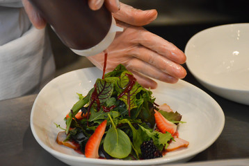 chef preparing salad from ham and leaf lettuce