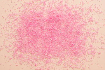 Home aroma therapy. Pink bath salt crystals scattered over peach surface. Abstract background. Copy space.