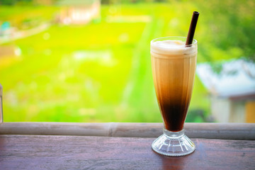 glass of homemade organic coffee with plantation background