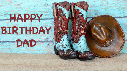 teal and brown cowboy boots and hat standing on a wood background with happy birthday dad in brown text on a teal background