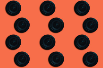 Black Camera Lens on a beautiful  coral orange background.