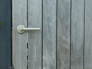 background. closed door with rusty door handle, the door is made of vertical boards gray color. closeup