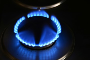 Fuego encendido en el quemador de una hornilla de gas