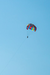 The operated parachute flies in high in the blue sky