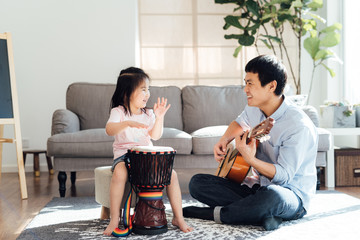 Father and daughter playing musical instruments