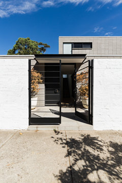Contemporary architectural home facade with welcoming open gate