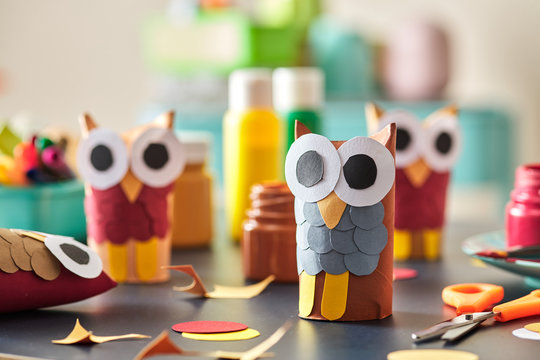 Cute handmade owls made from paper and paint on desk.