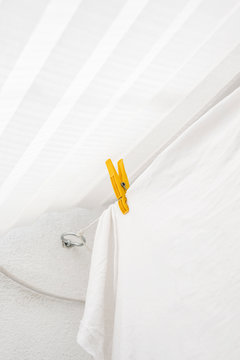 Yellow clothes peg on a white laundry