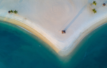 An aerial shot of a lone swimmer floating in the water at sunset.
