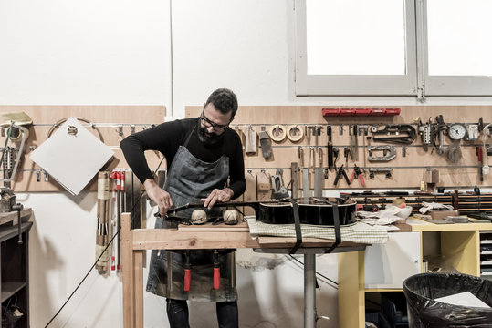Guitar luthier working in his workshop