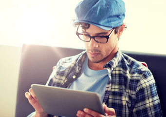 leisure, technology, communication and people concept - creative man with tablet pc computer sitting at cafe table