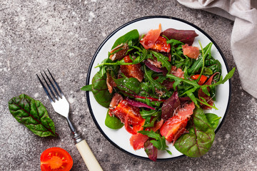 Healthy salad with prosciutto and tomato
