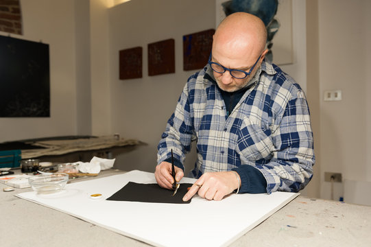 A Master Calligrapher writing elegant cursive lettering with a nib mounted on a oblique holder