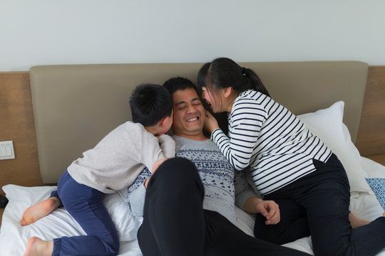 happy asian family of four in home