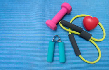 Fototapeta na wymiar Healthy lifestyle for heart sport dumbell equipment fitness on blue wood background. Healthy Concept 