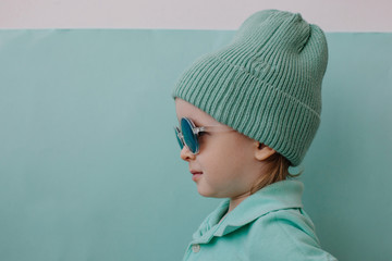 Profile portrait of fashionable boy wearing beanie and sun glasses