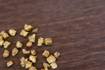 Fototapeta na wymiar mound of gold nugget on dark wood background