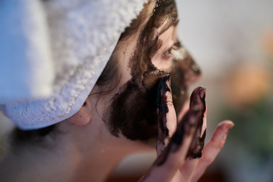 Close-up of girl applying mud mask