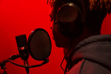 Young black man singing in studio
