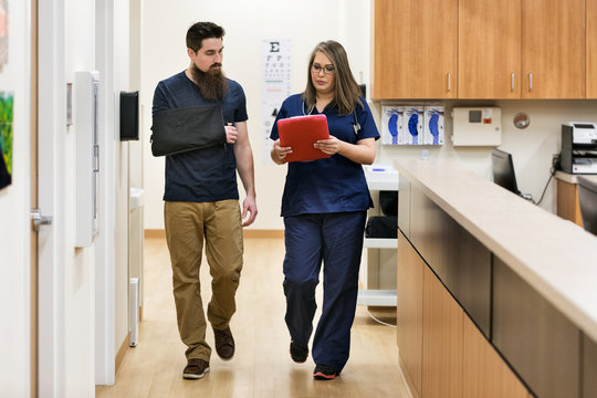 Clinic: Patient And Nurse Discuss Injury In Hallway
