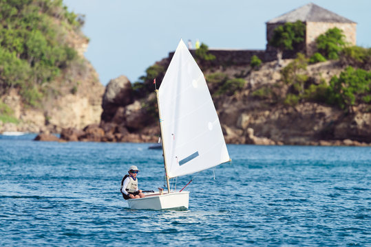 Boy in an optimist dinghy in English Harbour in Antigua