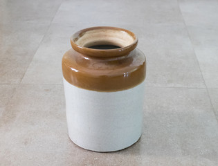 White and brown vase on the floor of ceramic tiles. Kochi, Kerala, India
