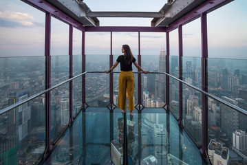 Tourist gazing the views of Kuala Lumpur from a skybox in Menara's Tower