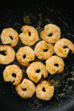 Frying king prawns in a black pan