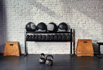 A sunlit empty gym with a rack of weights.