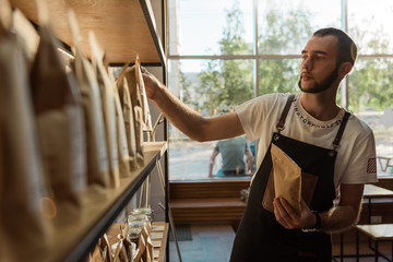 Man composing coffee packs in shop