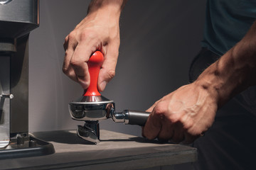 Man compressing freshly grounded coffee