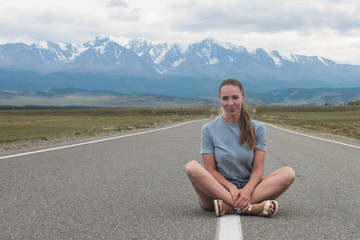 Woman sitting on the beauty road in mountain