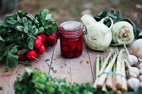 Vegetables and a jar on a wooden table