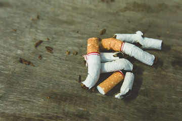 Stop cigarette, broken cigarettes on wood background