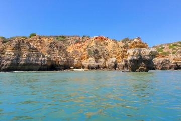 Panoramic landscape view of golden cliffs and emerald water in Ponta da Piedade, Lagos, Algarve, Portugal