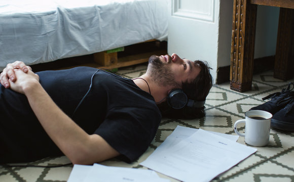 Young man resting on floor listening  music.