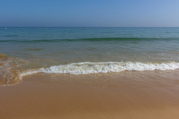 Fototapeta na wymiar Soft wave ocean on golden sandy beach, background, Algarve, Portugal