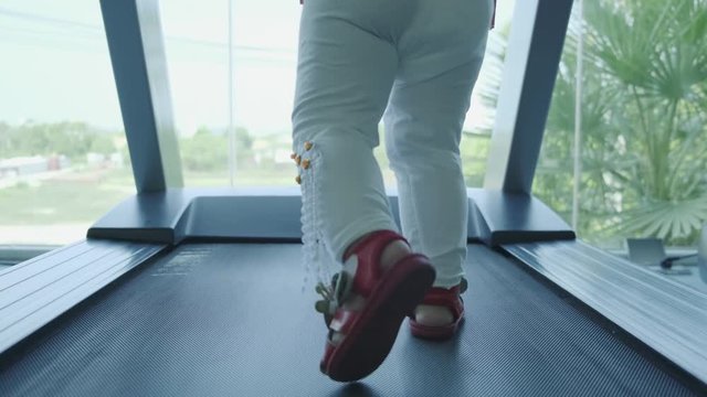 baby feet on the treadmill in the gym