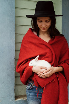 Young woman holds tiny white rabbit